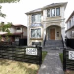 Modern two-storey residential home with elegant exterior, landscaped front yard, and black metal fencing, located in a desirable neighborhood in Vancouver, BC.