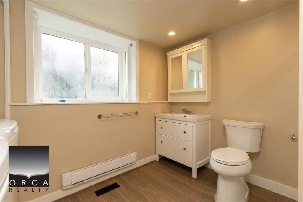 Bright bathroom with natural light, white vanity, and modern fixtures, designed for comfort and function in a residential home in BC.