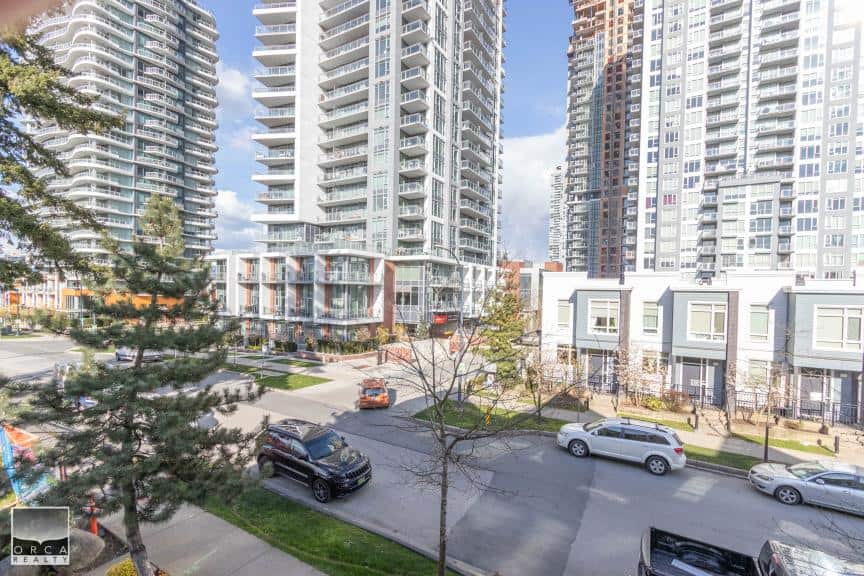 Modern high-rise condominium buildings in downtown Vancouver with retail spaces on the ground floor, surrounded by landscaped walkways and parking areas, representing prime real estate opportunities.