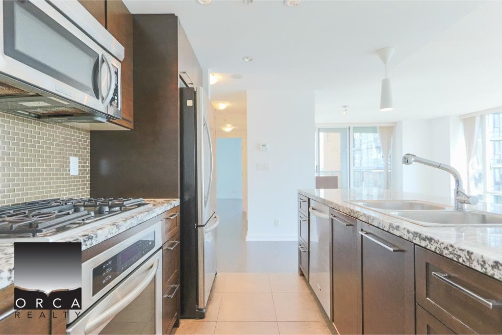 Stainless steel appliances in a modern kitchen with granite countertops, perfect for Vancouver real estate listings and property searches.
