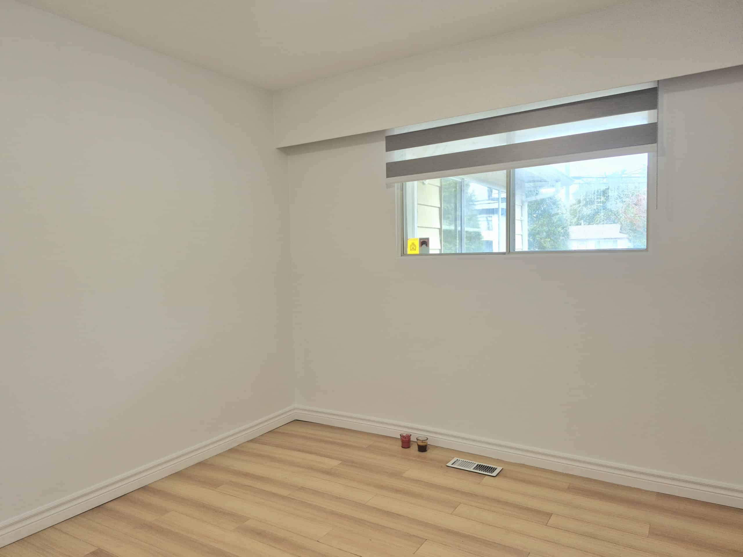 20250920_141628 Bright empty room with a large window, white walls, and light wood flooring, showcasing modern condo or apartment interior ideal for real estate listings.