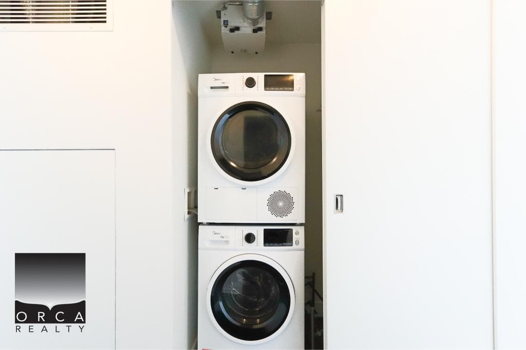 Front-loading washer and dryer set in a modern laundry nook showcasing efficient home appliances for Vancouver real estate.