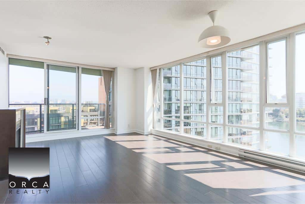 Bright modern high-rise condo living space with panoramic city and water views, showcasing contemporary interiors and large floor-to-ceiling windows in downtown Vancouver.