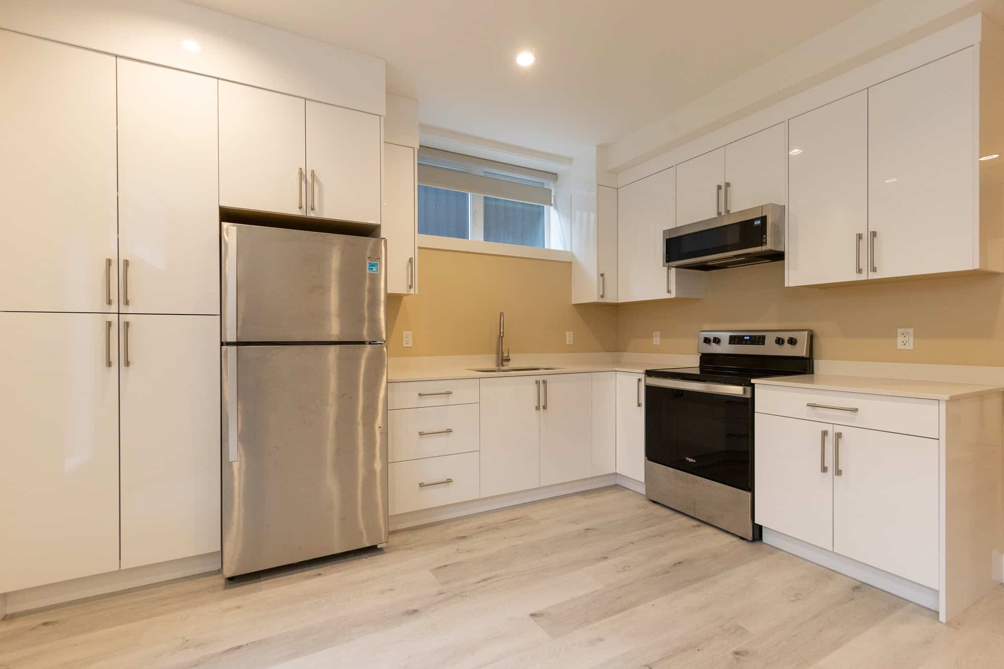 5 Bright modern kitchen with white cabinetry, stainless steel appliances, and beige walls, perfect for Toronto real estate listings and homebuyers.