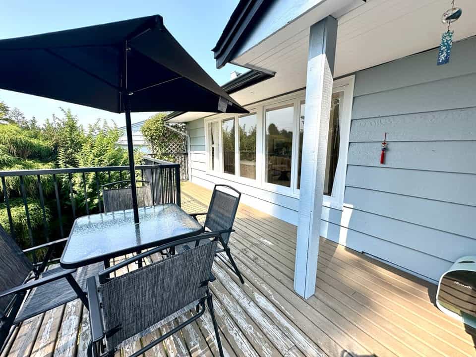 Spacious outdoor deck with patio furniture and umbrella at a residential property listed by Orca Realty Inc. in Victoria, BC. Perfect for outdoor entertaining and enjoying the beautiful Pacific Northwest weather.