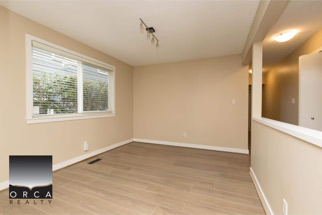 Bright and spacious living room with large window, neutral wall colors, and modern flooring, ideal for homebuyers seeking comfortable, stylish interiors in Victoria, BC.