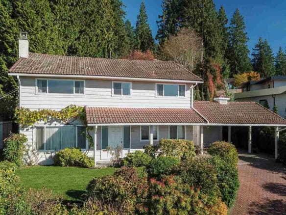 Charming two-story family home with lush front yard and mature trees, located in a peaceful Vancouver neighbourhood, ideal for real estate investment or family living.