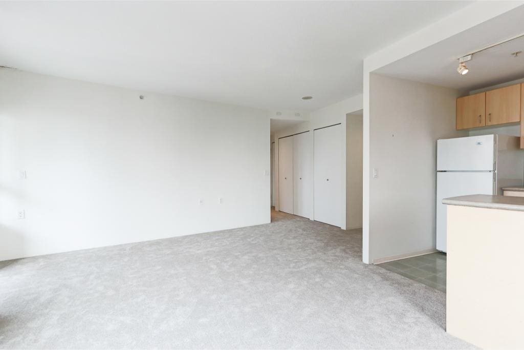 Bright and spacious living area in a modern Vancouver condo with updated kitchen and neutral decor, ideal for comfortable urban living.