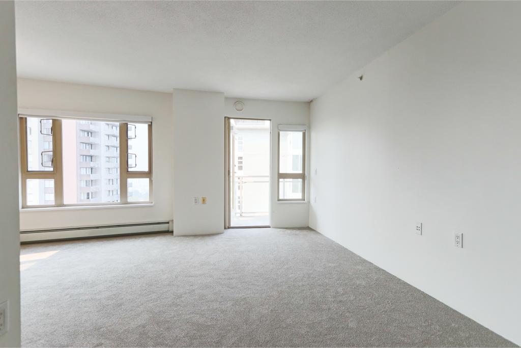 Bright vacant living room in a high-rise condo with large windows and city views, perfect for new homeowners or investors. Modern, clean space in Vancouver’s condo market.