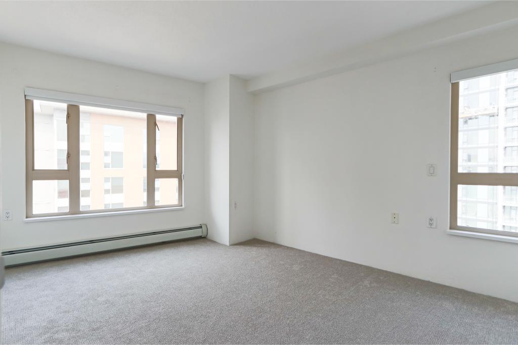 Modern bright apartment interior with large windows and neutral carpets, ideal for Vancouver city living. Perfect for real estate listings on Orca Realty Inc.