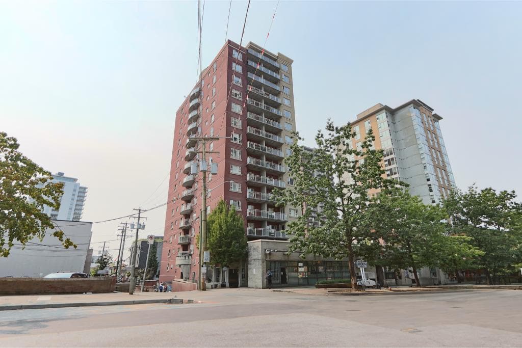 Modern Downtown Vancouver condo building with spacious balconies and retail spaces on the ground floor. Perfect for real estate investment or urban living in Vancouver's vibrant city center.