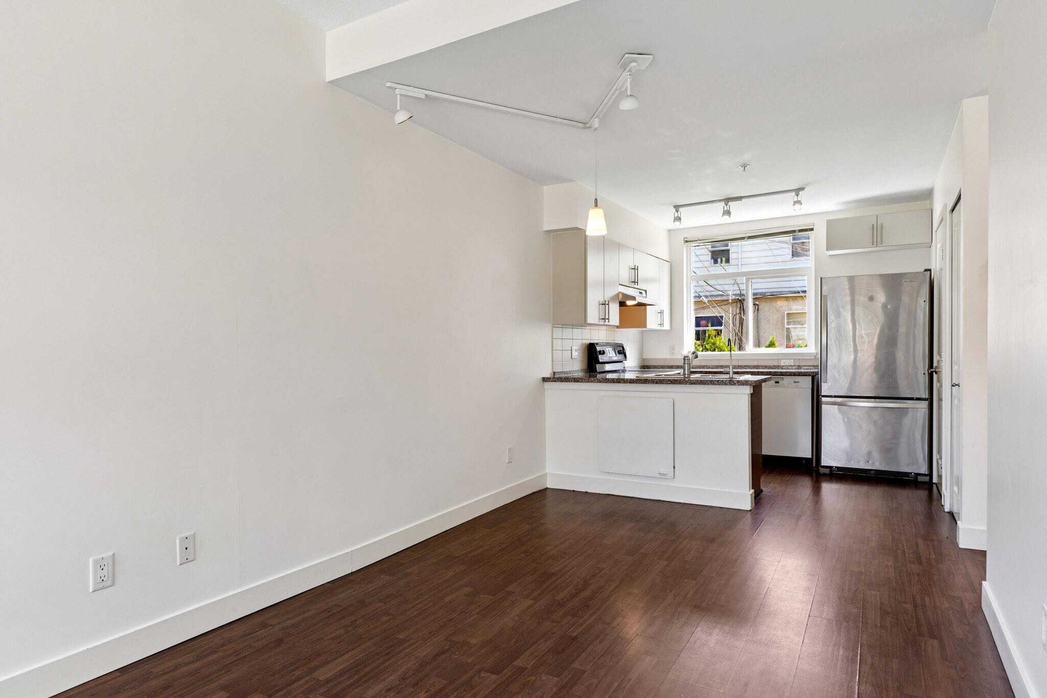 Modern kitchen with stainless steel appliances and ample natural light, ideal for Vancouver real estate buyers seeking stylish and functional homes.