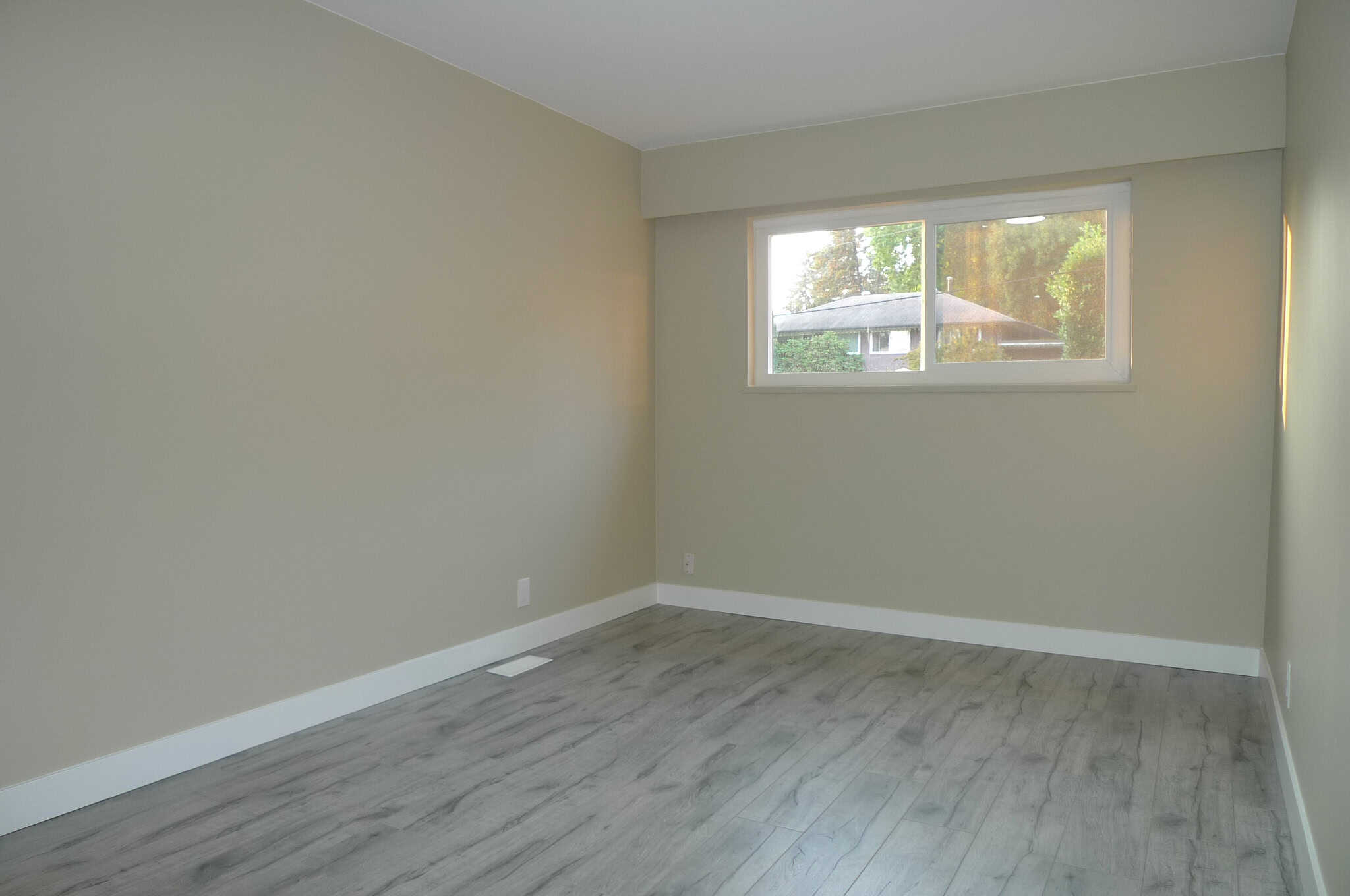 Bright and spacious empty room with large window, ideal for home staging or real estate listings in Vancouver.