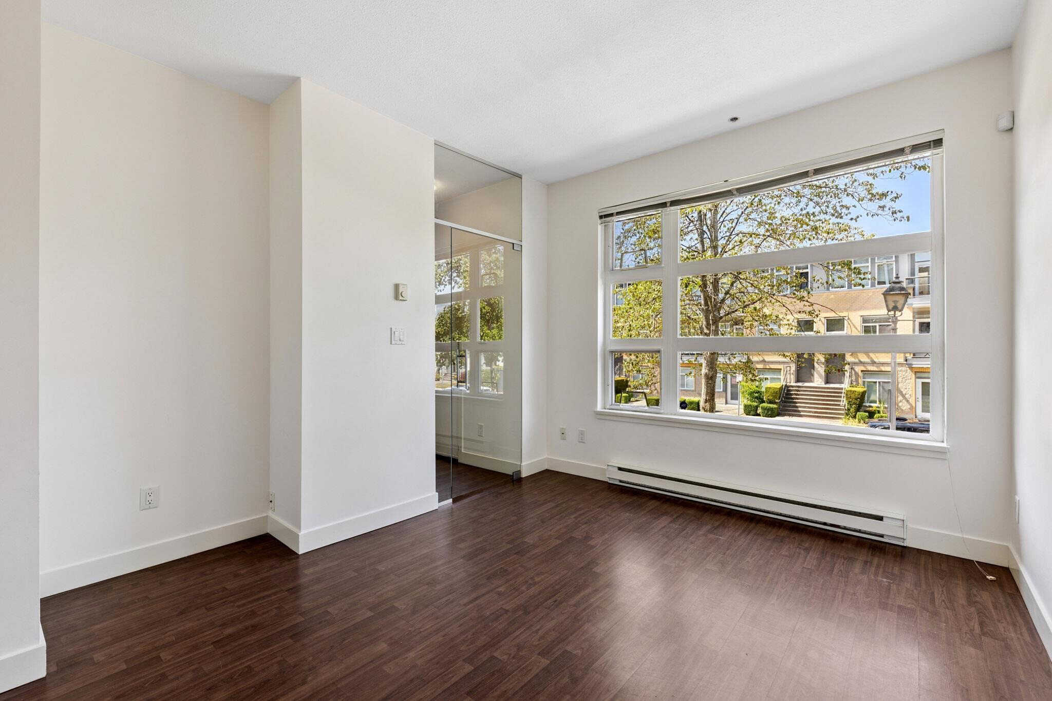 Bright unfurnished Canadian apartment with large windows and hardwood floors, ideal for modern home living and real estate investment in Vancouver.
