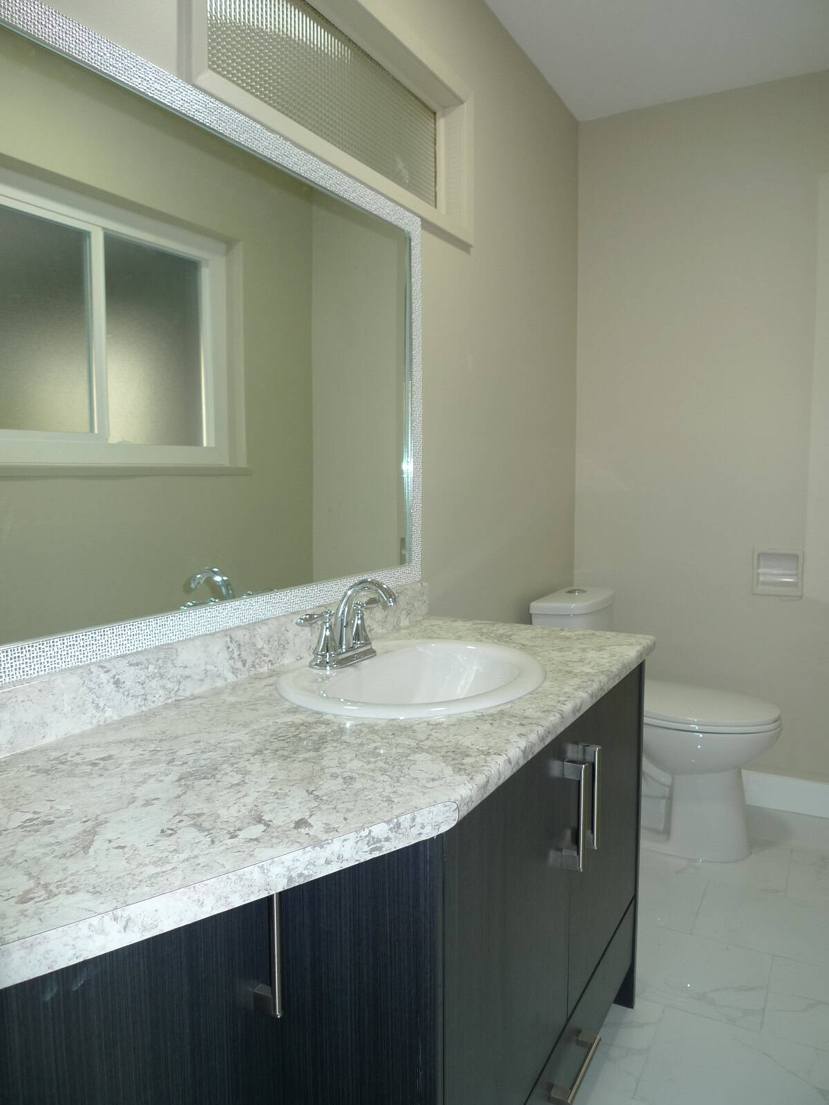 Modern bathroom vanity with marble countertop and white undermount sink at Orca Realty Inc. real estate listings.