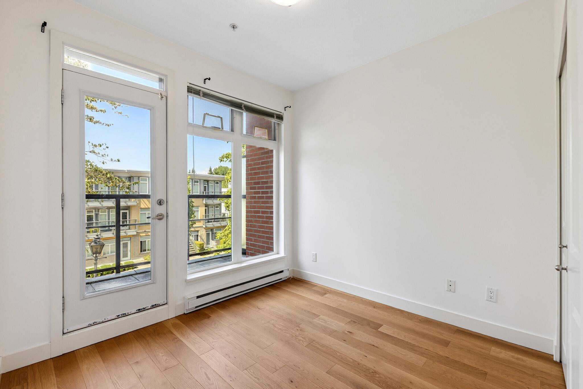 Bright living room with large windows and balcony access, featuring natural light, hardwood floors, and modern interior design, perfect for Vancouver real estate buyers.