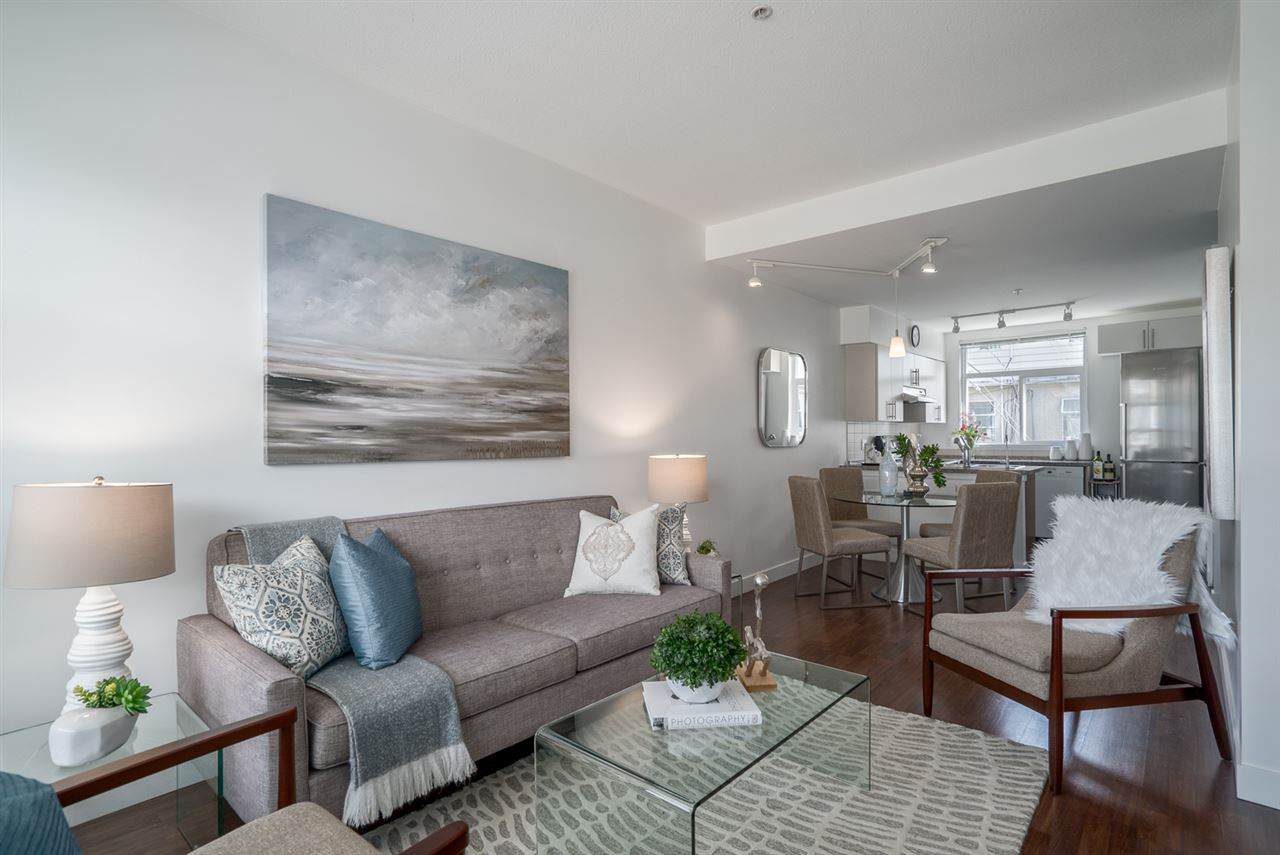 Contemporary living room and kitchen in modern downtown condo, featuring stylish furnishings, natural light, and open-concept design, perfect for Vancouver real estate listings.