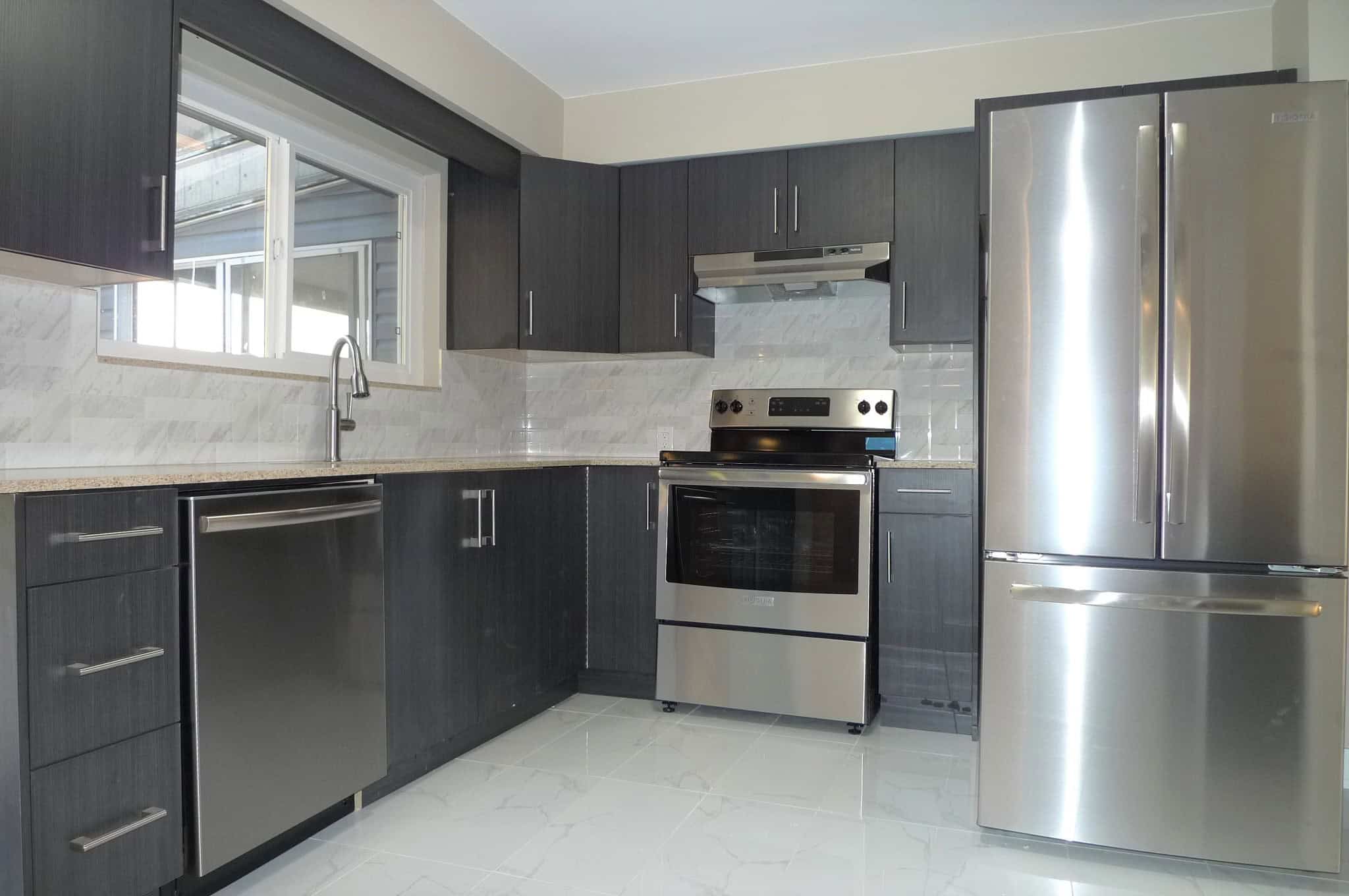 Modern stainless steel appliances in a contemporary kitchen at Orca Realty Inc., showcasing stylish dark cabinetry, a spacious layout, and premium features perfect for Vancouver-area homes.