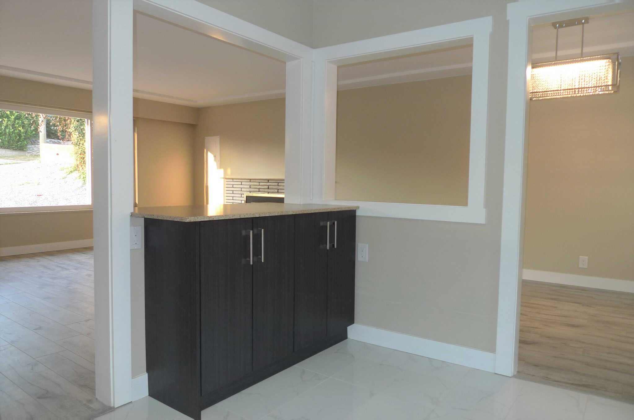 Modern kitchen interior with dark wood cabinets, granite countertops, and open layout, ideal for homebuyers seeking contemporary residential real estate in Vancouver.