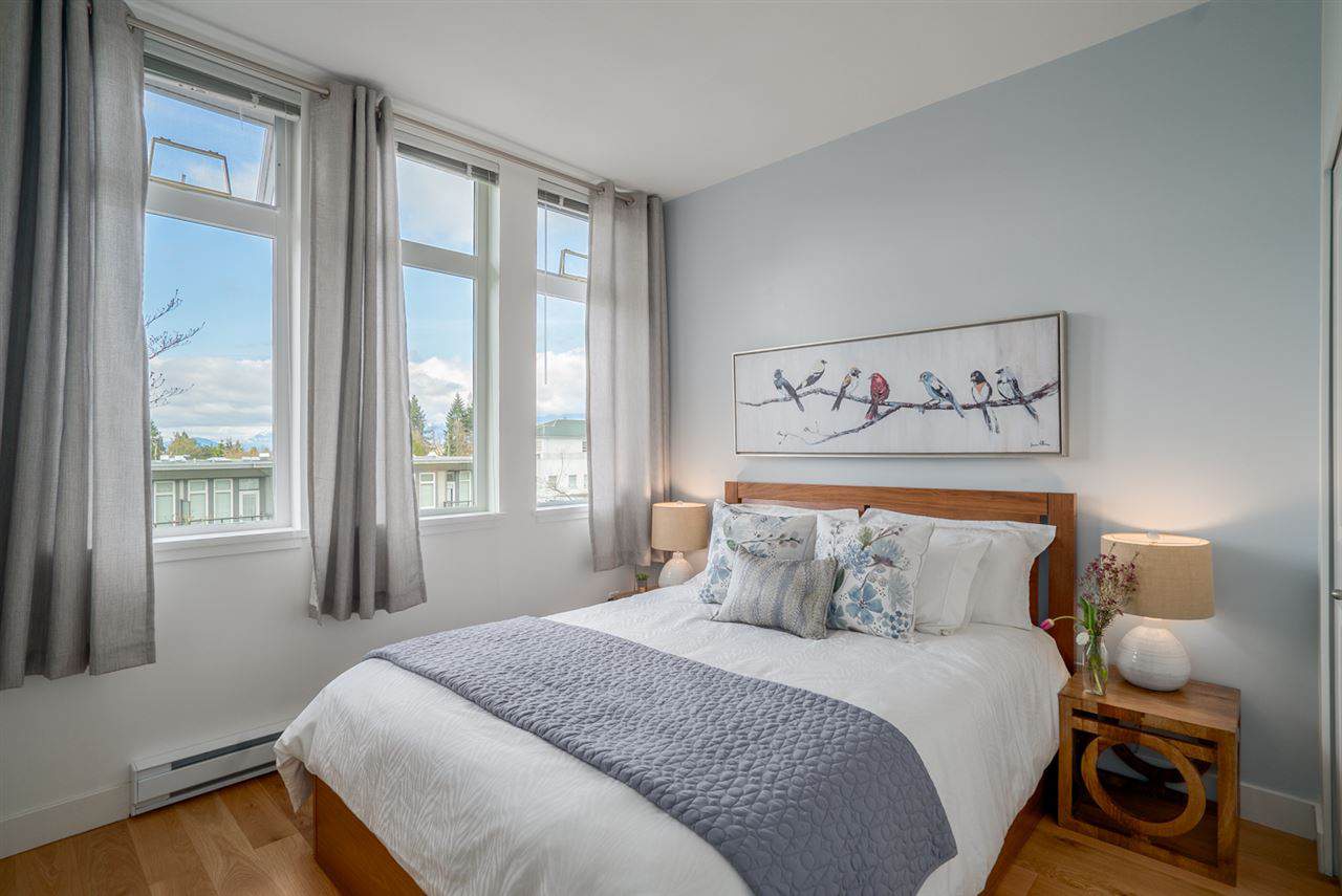 Modern bedroom with large windows, ambient lighting, cozy bedding, and tasteful decor, ideal for Vancouver Island homebuyers and real estate investors in BC.