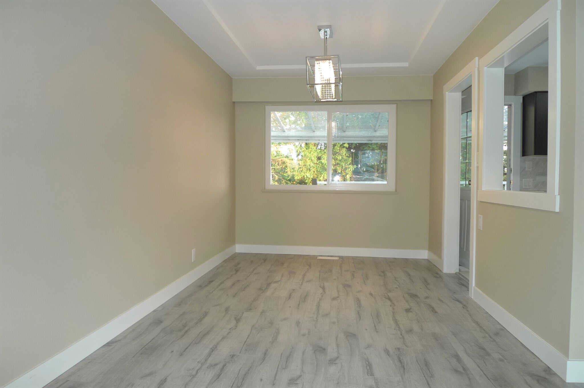Bright and modern dining area with large window and neutral decor, perfect for family gatherings or entertaining guests.