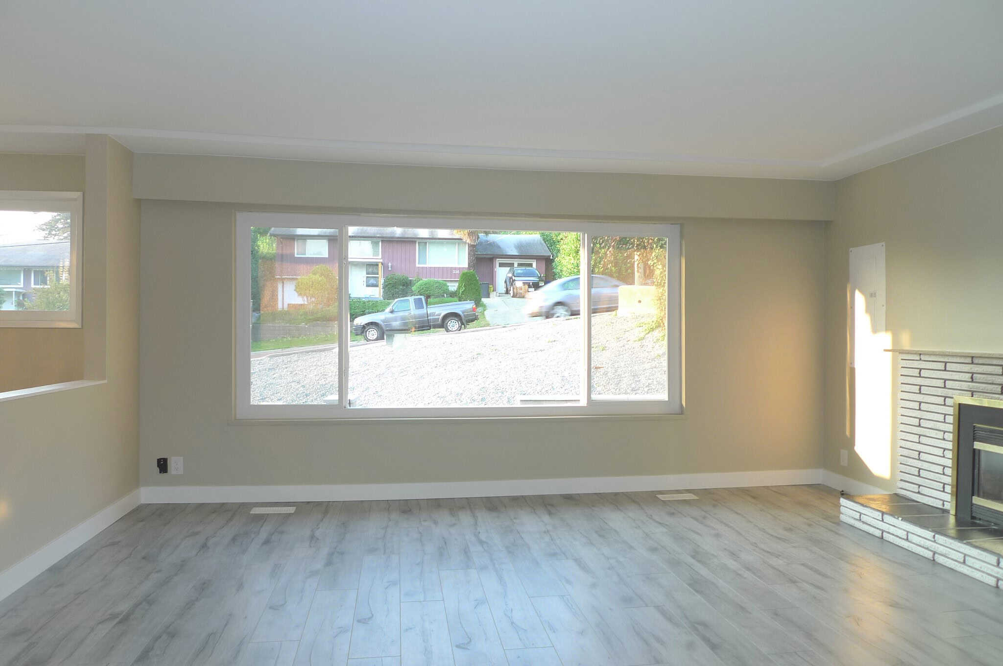 Bright living room with large window views in a Vancouver Island home listed by Orca Realty Inc., showcasing modern interior design and waterfront real estate.