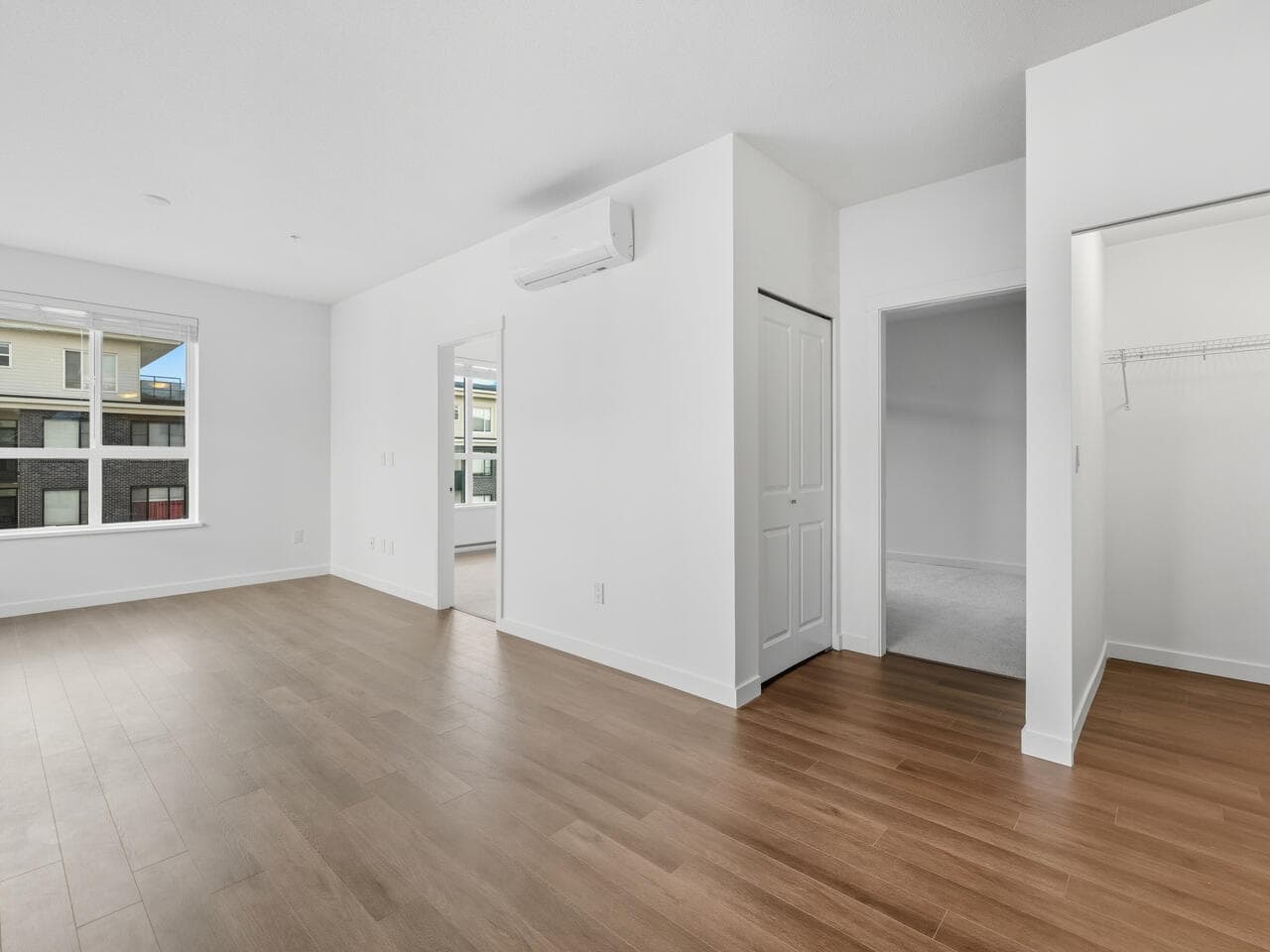 Bright, modern interior of a rental property in Vancouver with white walls, light wood flooring, large windows, and spacious closets, ideal for buyers seeking comfortable living spaces.