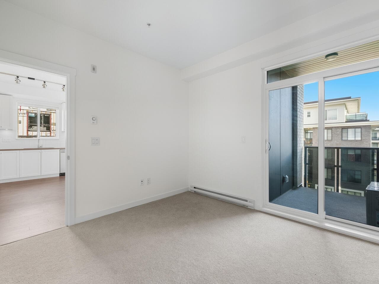 Bright modern condo living space with large sliding glass door opening to balcony, featuring natural light and urban views, ideal for Vancouver or nearby area homebuyers, presented by Orca Realty Inc.