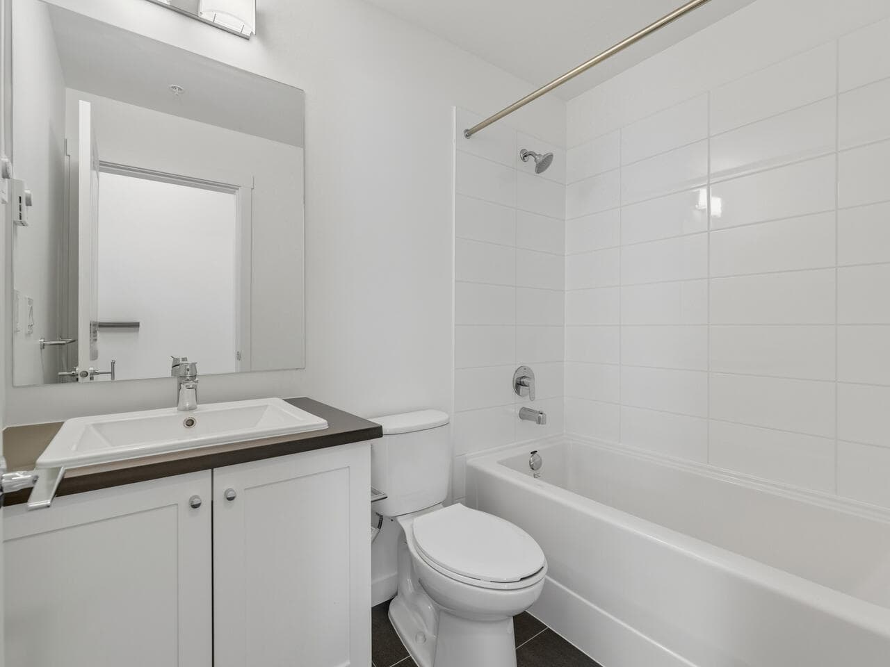 Bright, modern bathroom with sleek white tiles, contemporary sink, and clean design, showcasing quality finishes suitable for Vancouver properties.