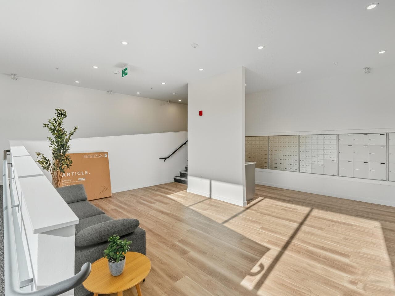Bright modern apartment interior with abundant natural light, clean white walls, wooden flooring, and communal mailboxes, ideal for Vancouver or Fraser Valley real estate in British Columbia.