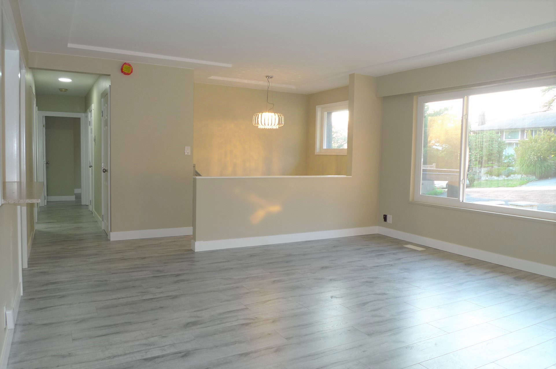 Bright, spacious living room with large windows, light-colored walls, and modern flooring, ideal for Winnipeg homes in need of real estate expertise.