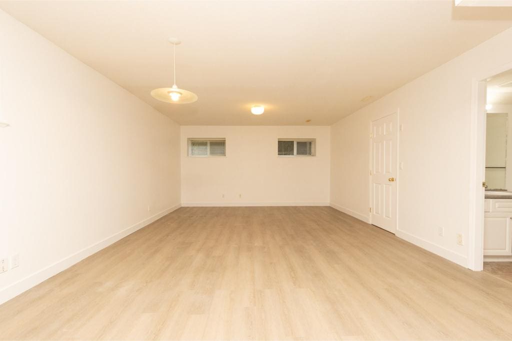 Spacious, empty basement in a Vancouver-area home with neutral tones, perfect for real estate investment or family living.