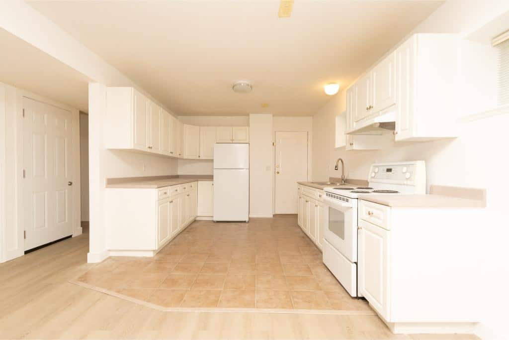 Bright white kitchen with modern appliances, ample cabinet space, and a tiled floor, perfect for Vancouver real estate listings and property searches in Orca Realty Inc.'s portfolio.