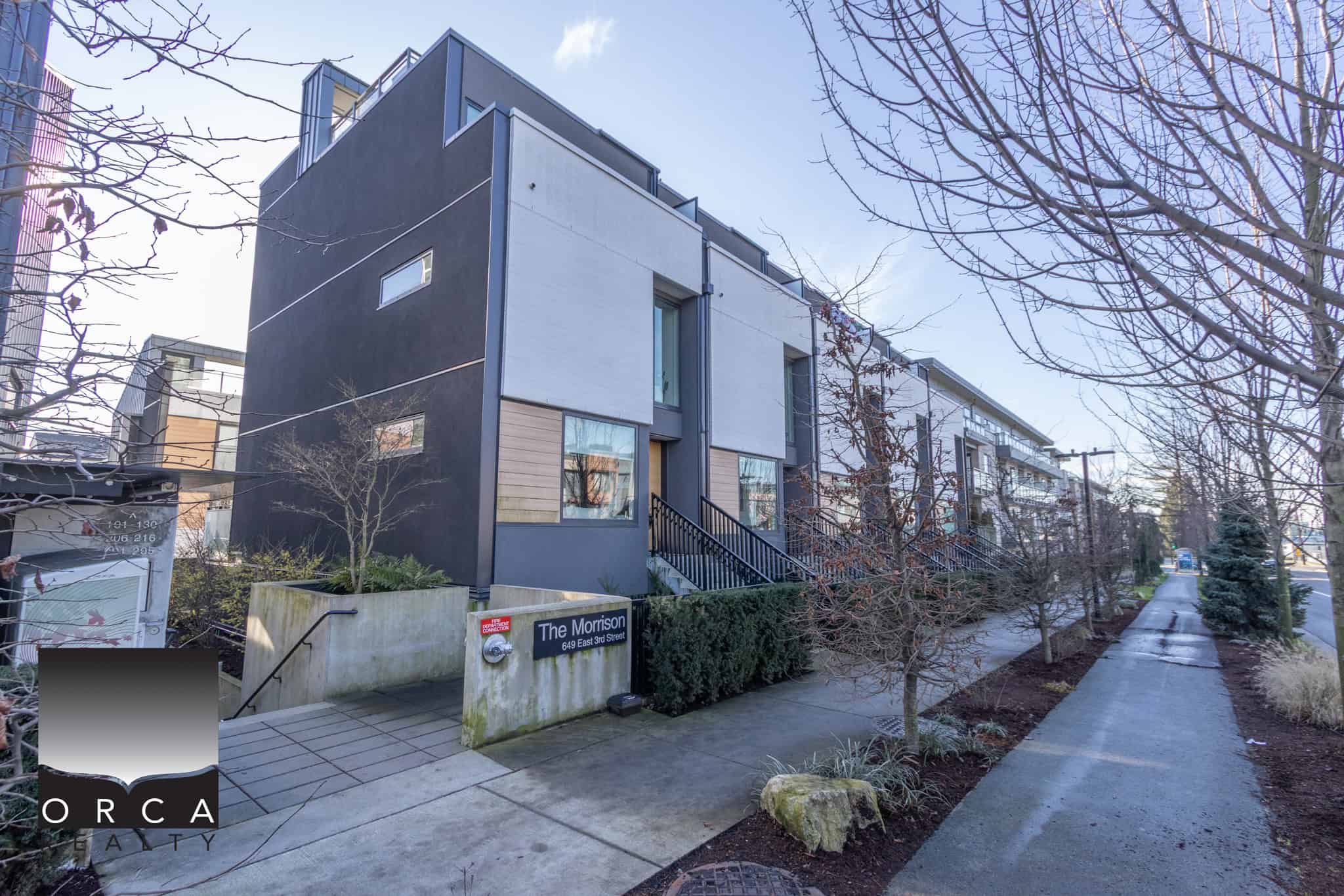 Contemporary condo building in North Vancouver, featuring sleek design and large windows, located at 103-649 3rd Street East, ideal for urban living and investment.