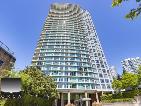 Luxurious modern high-rise condominium building in Vancouver with extensive glass windows and a curved architectural design.