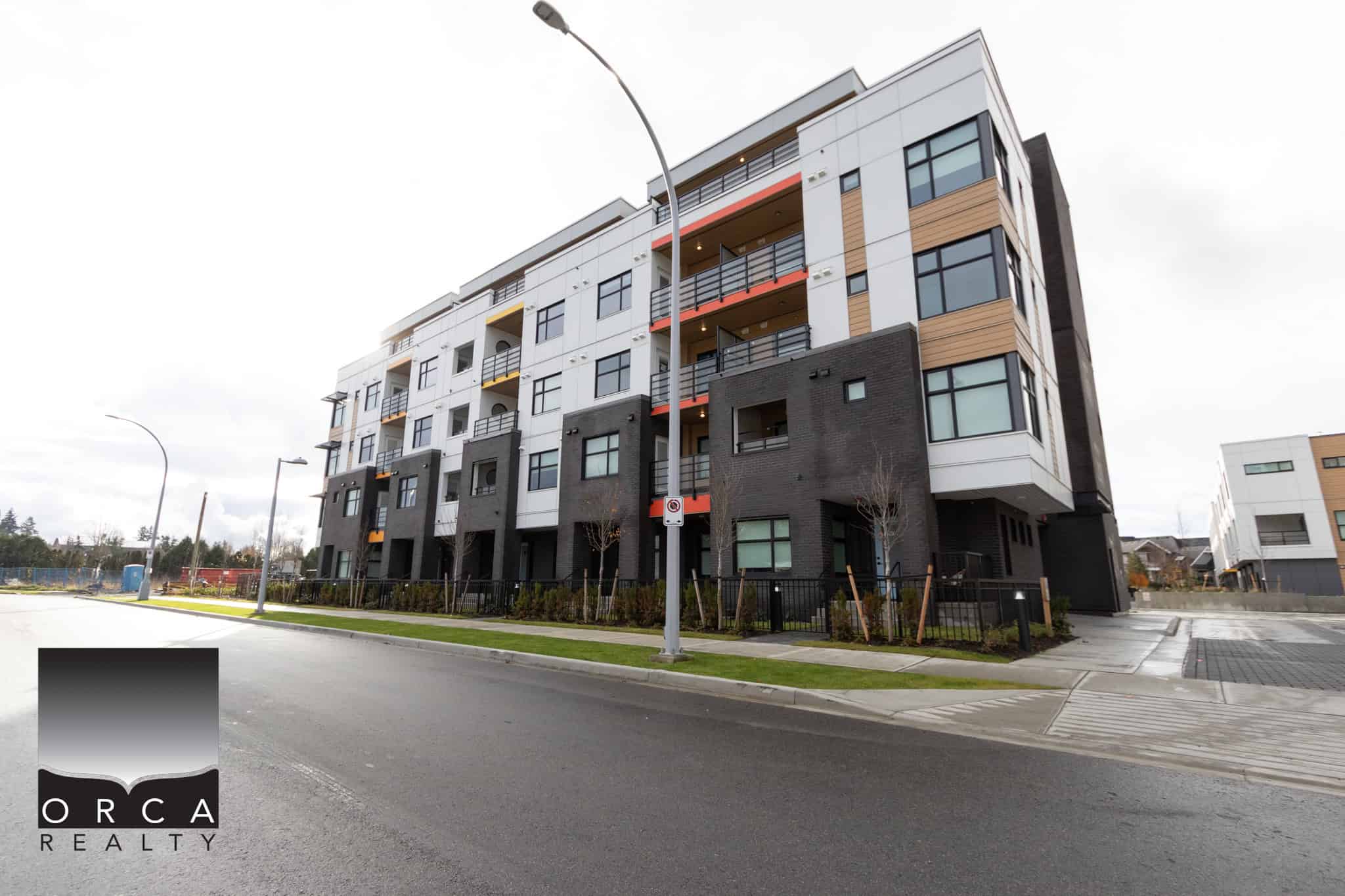 Contemporary multi-family residential building developed by Orca Realty Inc. showcasing modern architecture, clean design, and prime location in a vibrant urban setting in British Columbia.