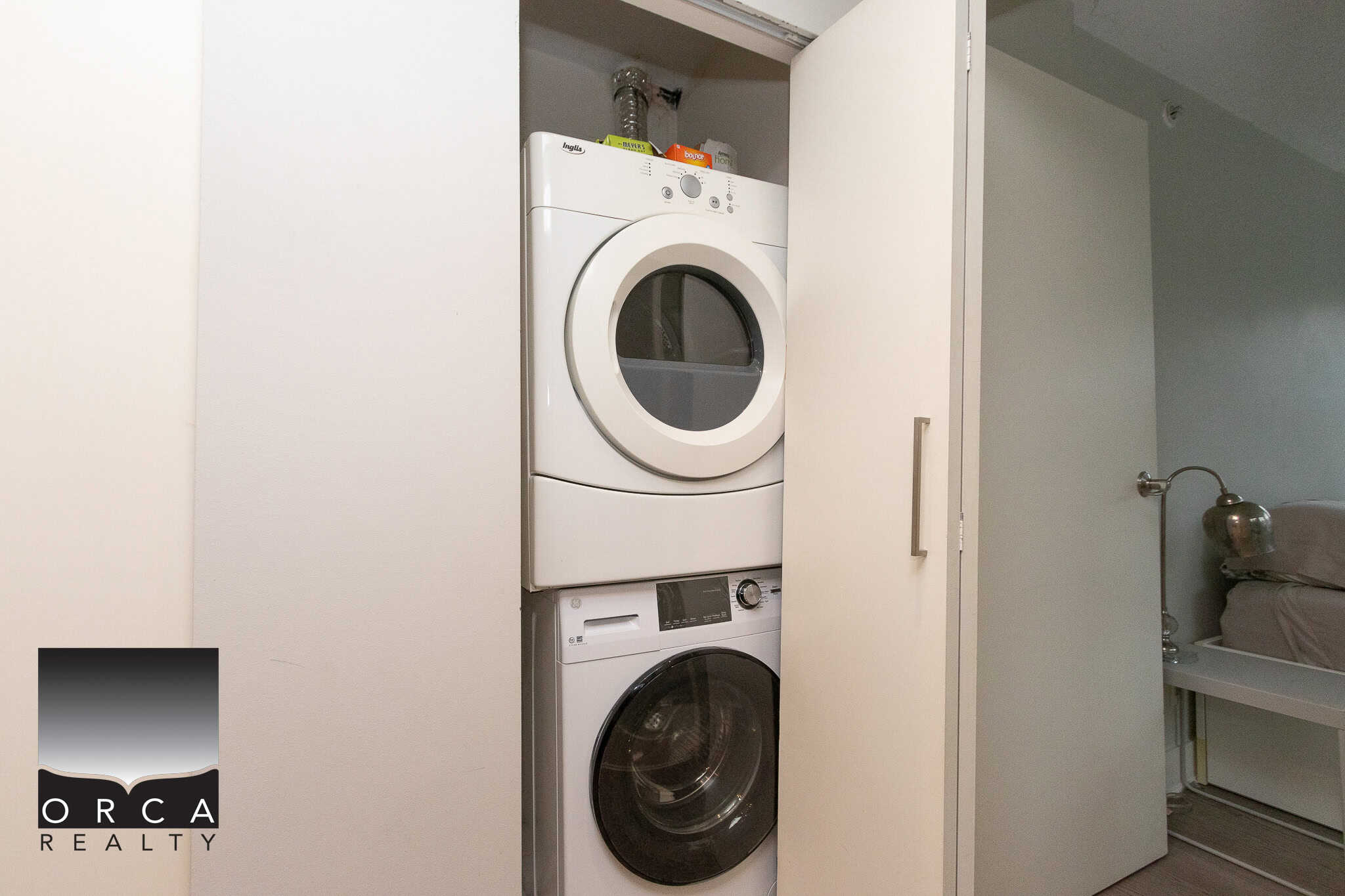Stacked washer and dryer inside a closet in a modern condo or apartment.