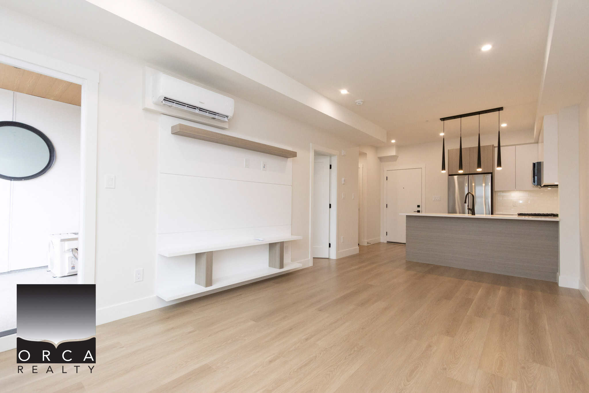Bright modern living room with open-concept kitchen, hardwood floors, sleek appliances, and minimalist design, perfect for Vancouver homebuyers seeking contemporary condos or townhomes.