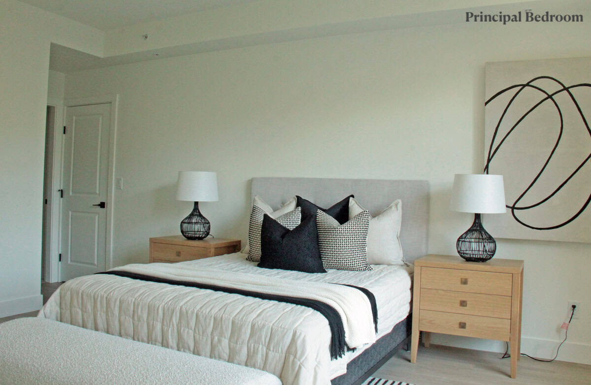 Modern main bedroom with neutral decor, stylish black and white accent pillows, elegant bedside lamps, and minimalist wooden nightstands, showcasing luxury Vancouver real estate by Orca Realty Inc.