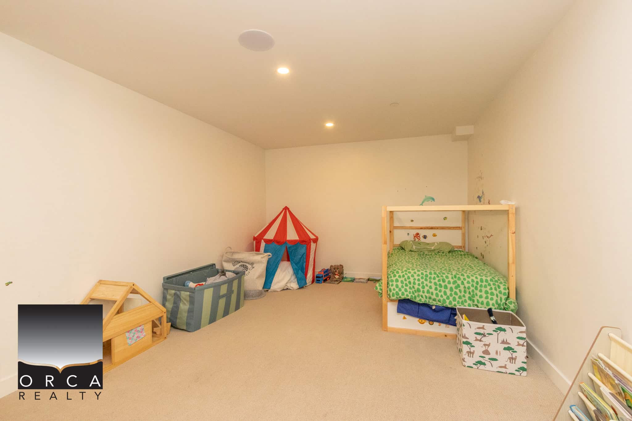 Bright and spacious basement bedroom in North Vancouver with a playful tent and storage solutions. Perfect for family living or guest accommodations.