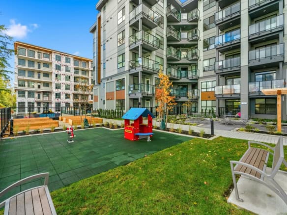 Bright modern Vancouver apartment building with a landscaped outdoor playground and seating area, perfect for families and residents seeking vibrant community living in Orca Realty Inc. properties.