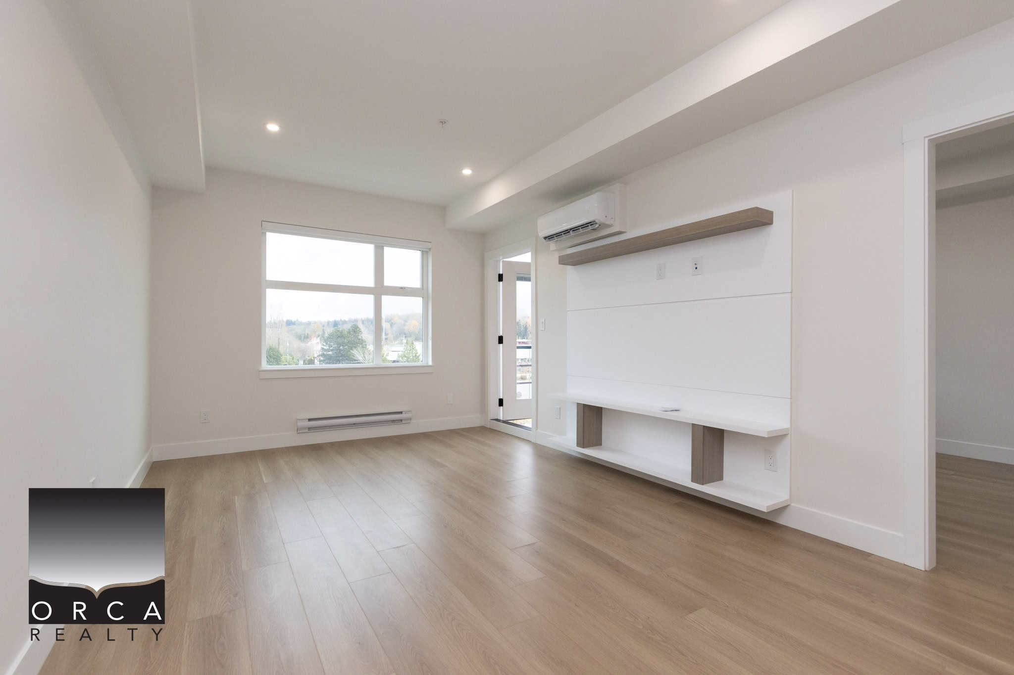 Bright spacious living room with large window, neutral wall color, modern interior, and hardwood flooring, ideal for Vancouver BC real estate listings and homebuyers searching for condos or apartments.