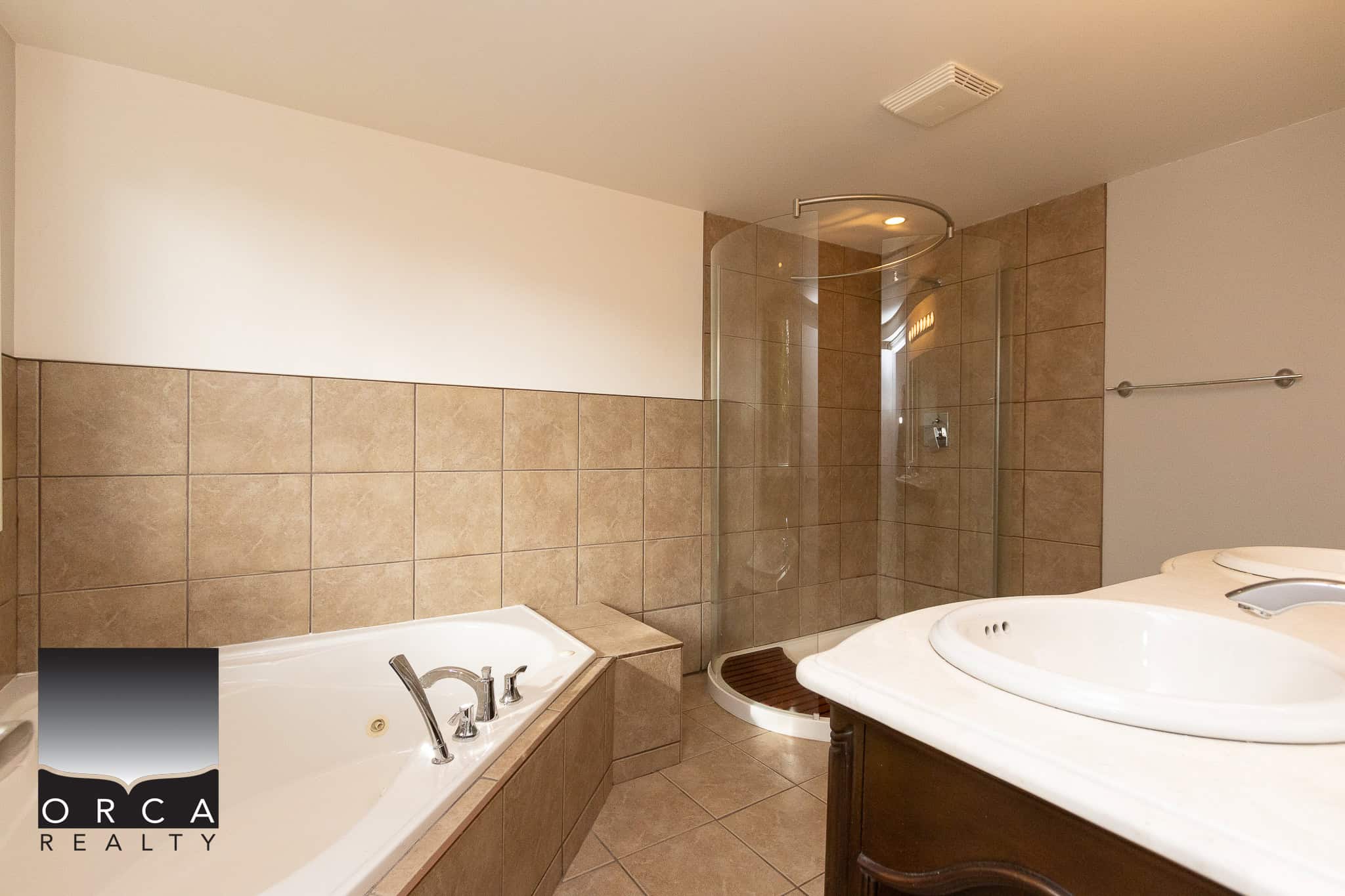 Luxurious bathroom with walk-in shower, soaking tub, and modern fixtures, perfect for relaxation in a dream property listed by Orca Realty Inc.