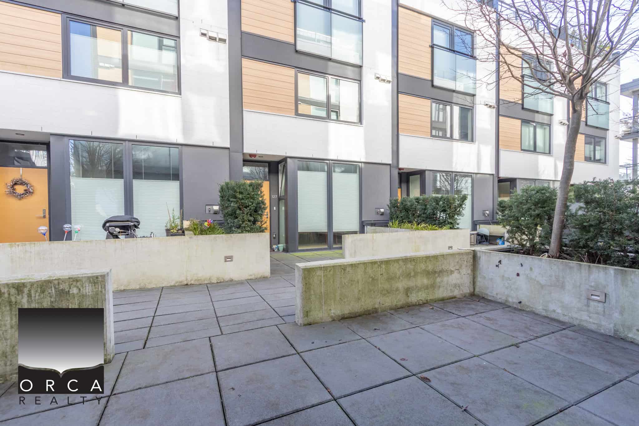 Bright, contemporary apartment building in North Vancouver with large windows and landscaped outdoor space.