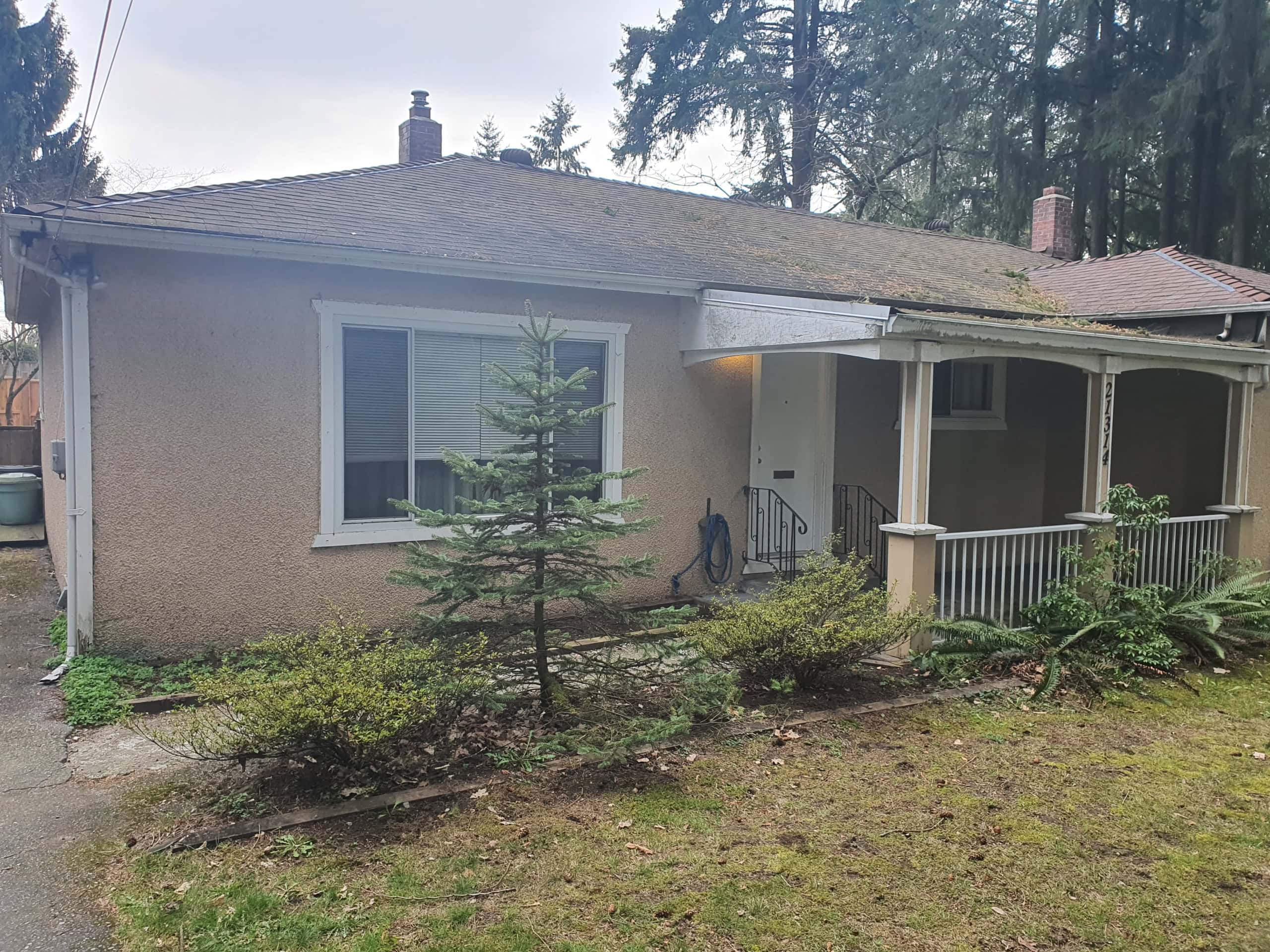Comfortable single-family home with a cozy porch, surrounded by greenery, perfect for families or investors seeking Vancouver Island real estate opportunities.