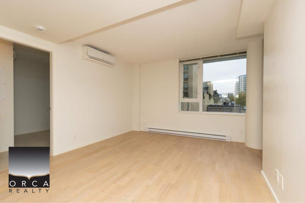 Bright, modern living room in Vancouver apartment with large window, hardwood floors, and Air Conditioning perfect for downtown living.