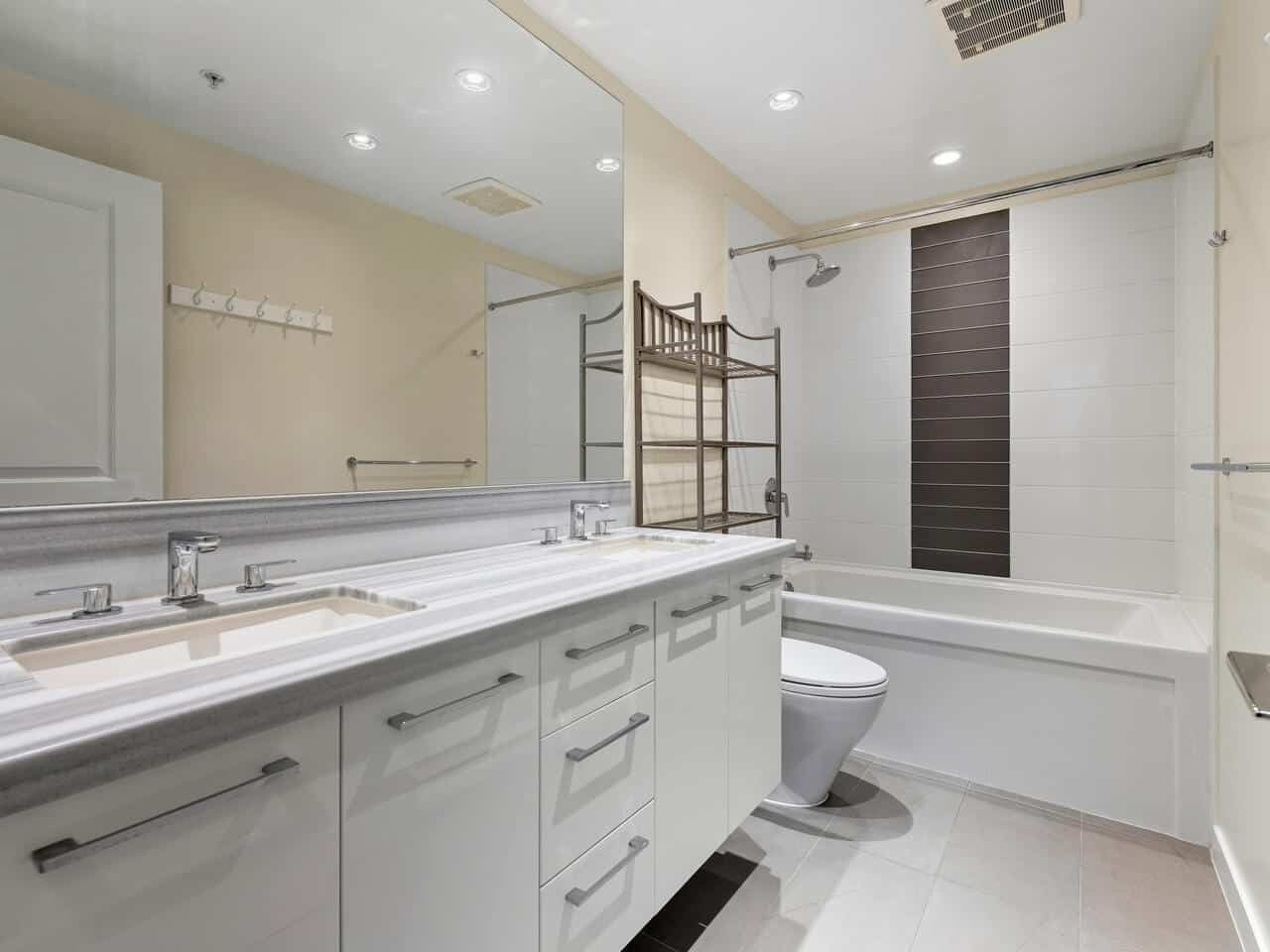 Modern bathroom with double vanity, bathtub, and shower, featuring neutral tones and contemporary fixtures, perfect for Vancouver real estate listings.