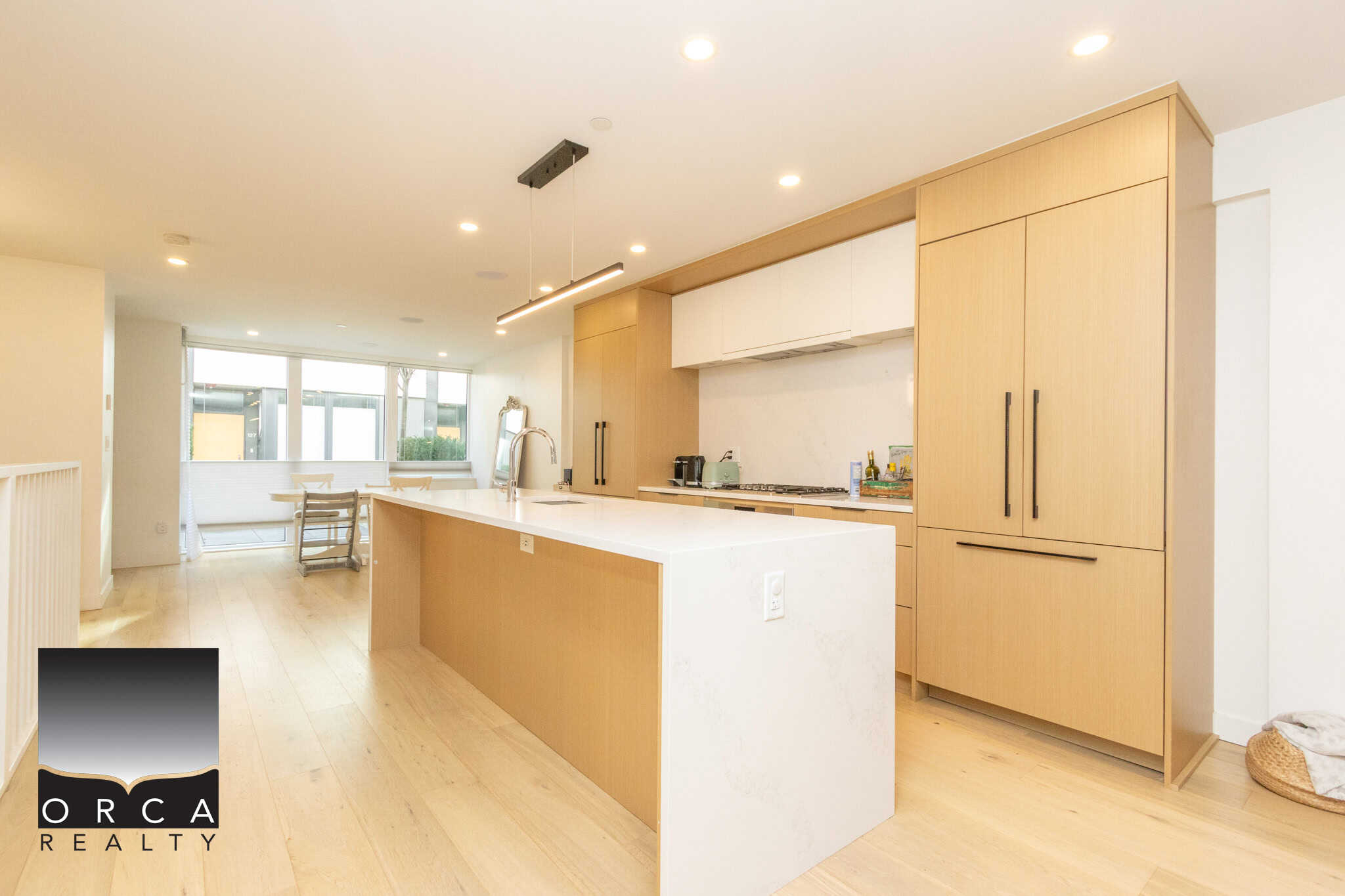 Spacious kitchen featuring sleek wooden cabinets, a large island, and ample natural light, ideal for contemporary North Vancouver living.