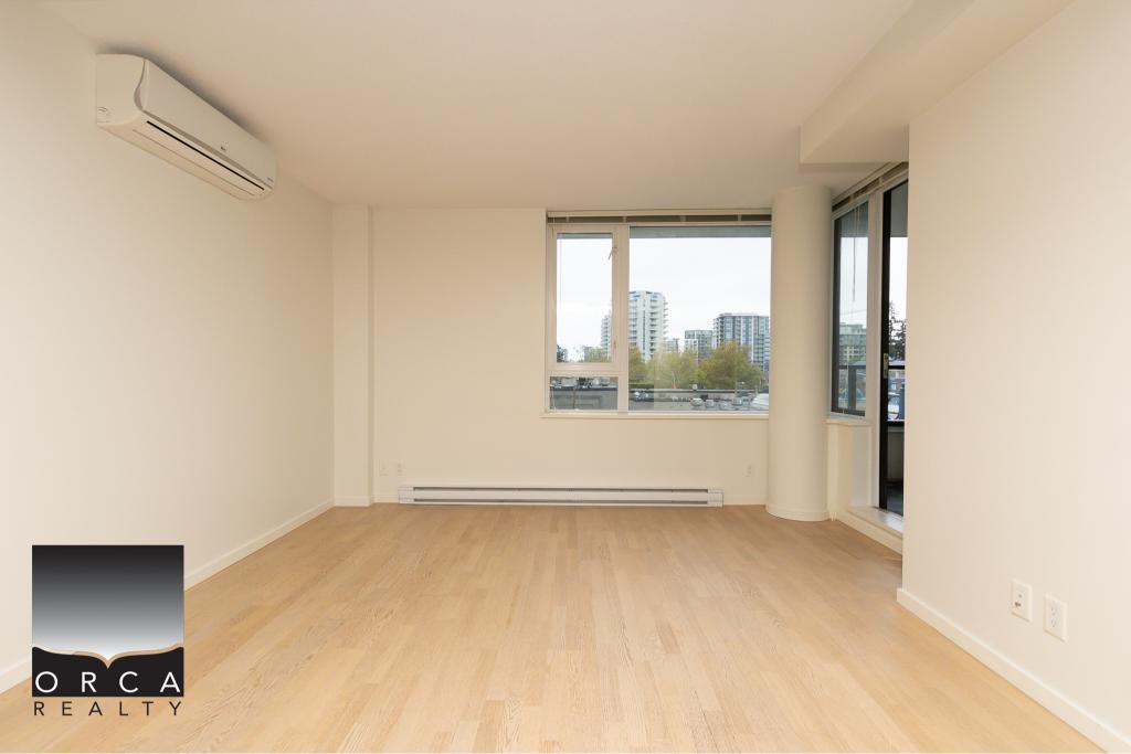 Bright living room with large windows and city views in an upscale condominium, featuring natural light, hardwood flooring, modern design, and a balcony, offered by Orca Realty Inc.