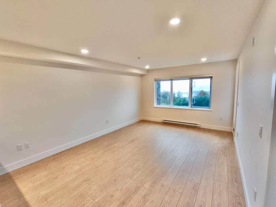 Bright spacious living room with large window, modern design, and hardwood flooring, ideal for Vancouver real estate buyers.